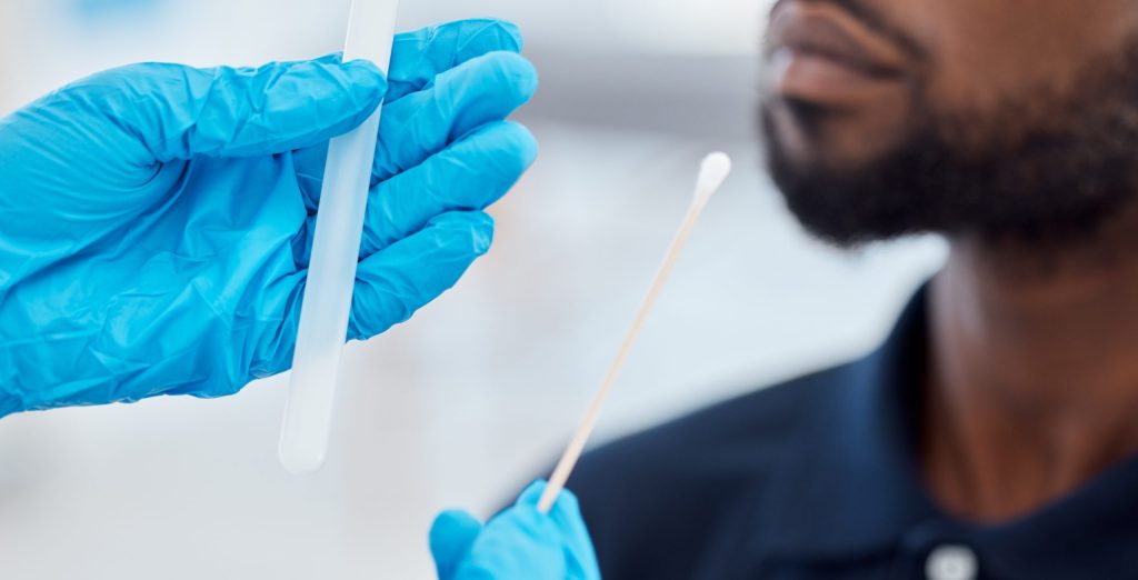 Doctor hands, compliance and a covid test with black man with testing kit in a clinic or hospital. Safety, medical pcr and healthcare hand, glove or corona check before with cotton swab and test tube.